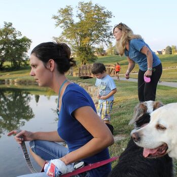 family with dogs near a lake